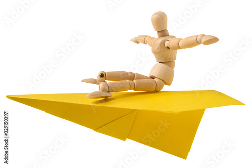 Wooden mannequin flying on a paper plane photo