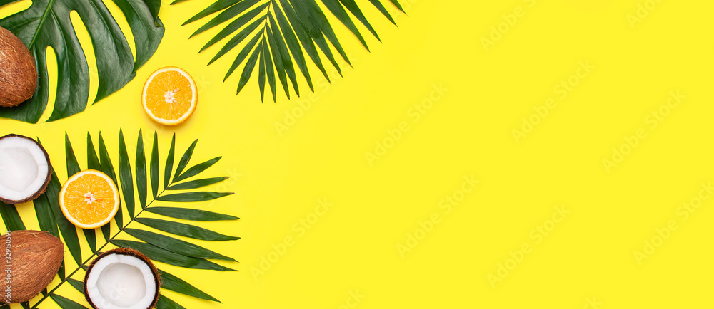 Summer tropical composition. Frame of Green tropical leaves of palm trees and monstera, coconut, orange on bright yellow background. Flat lay, top view, copy space. Creative background food, fruit - obrazy, fototapety, plakaty 