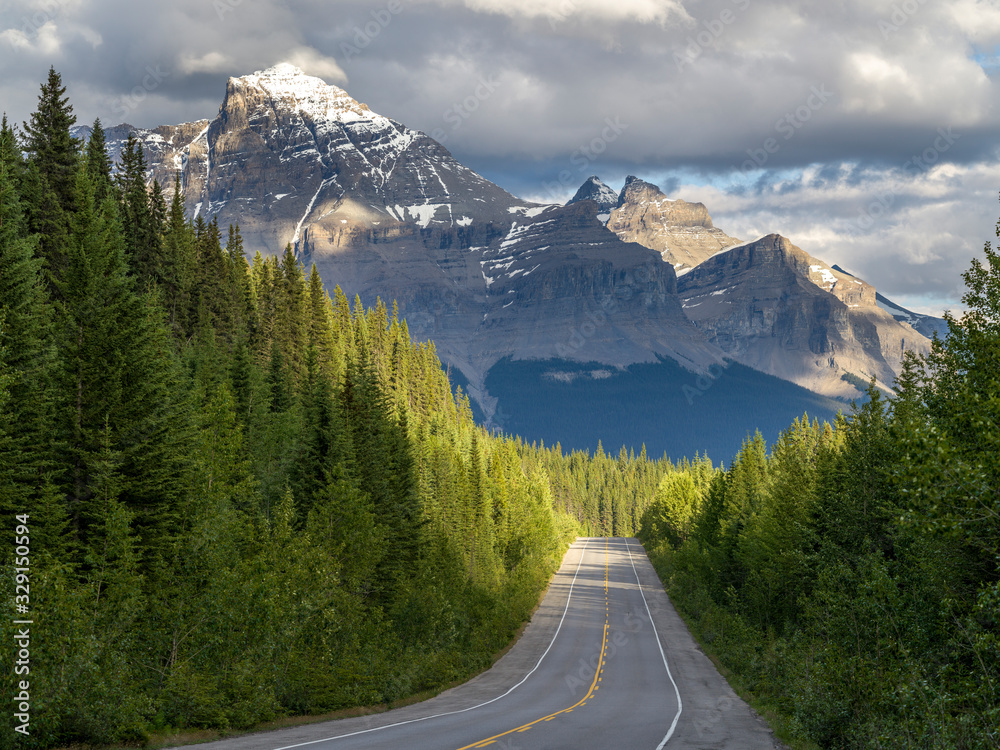 Road with snowcapped mountain range in the background, Icefield Parkway, Alberta, Canada