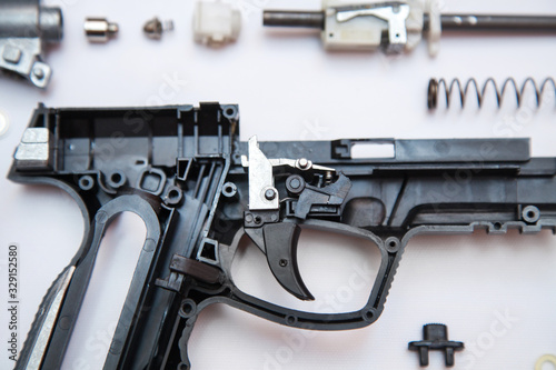 gas gun lies disassembled on a white background