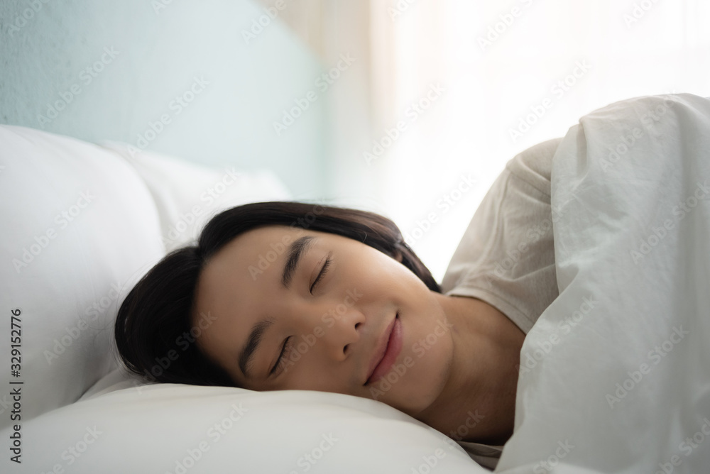 Asian Young man sleeping well and dreaming in white bed. Asian Young man sleeping well and dreaming in white bed.