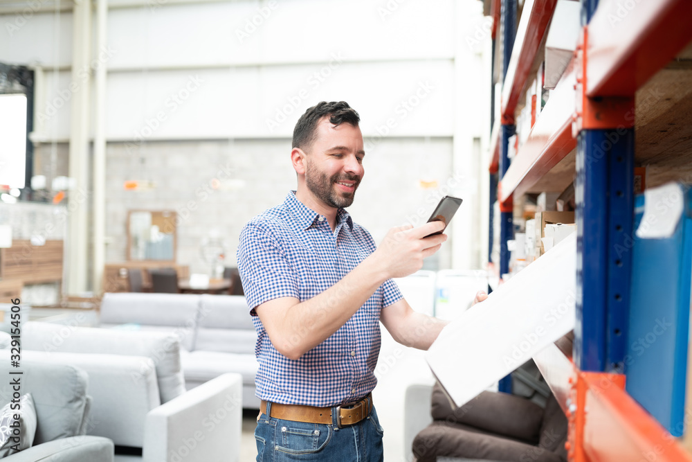 Fototapeta premium Handsome Male Customer Using Mobile Phone While Shopping