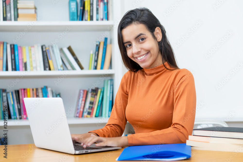 Lachende türkische Studentin am Computer Lachende türkische Studentin am Computer