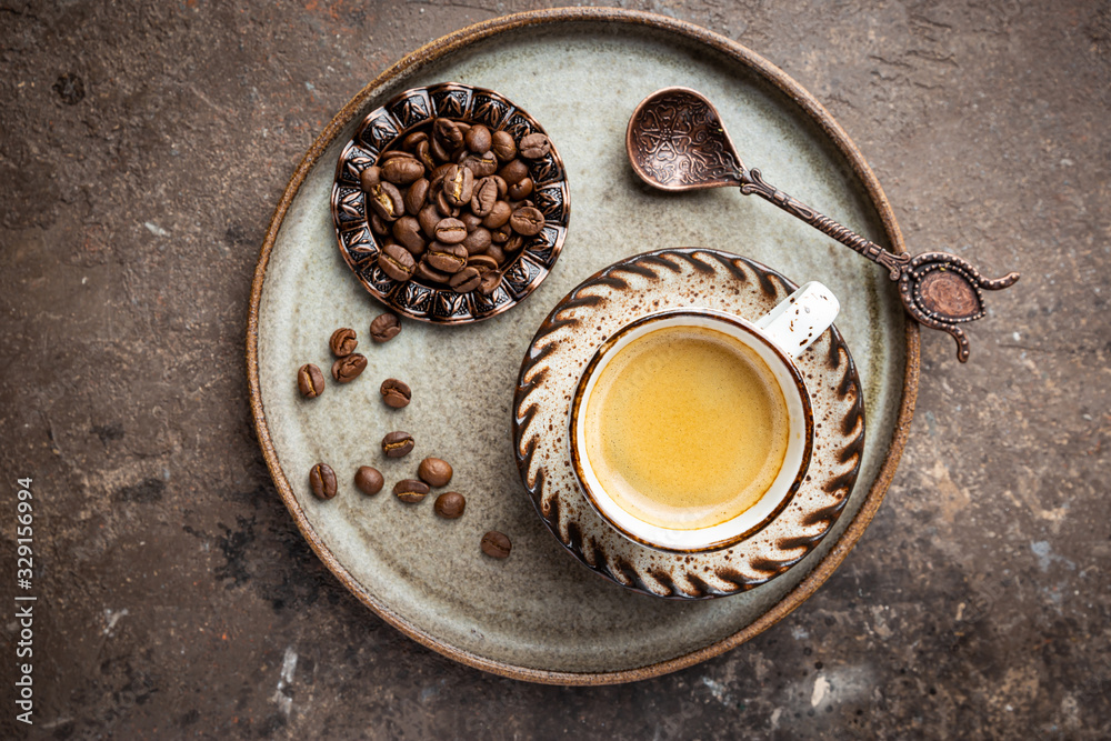 Top view cup of hot coffee with roasted coffee beans on dark background Top view cup of hot coffee with roasted coffee beans on dark background