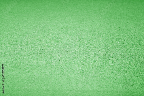 Plastic glittering texture with blur effect in green tone.