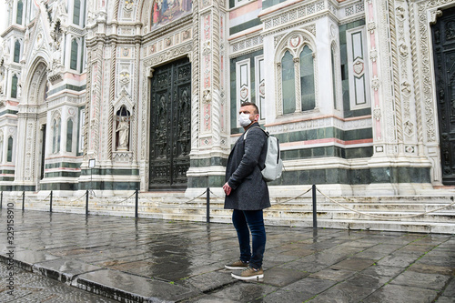 Coronavirus Covid-2019 in Italy. Man in a protective medical mask on a street in a city in Florence Italy. Streets and squares of Italy without tourists.