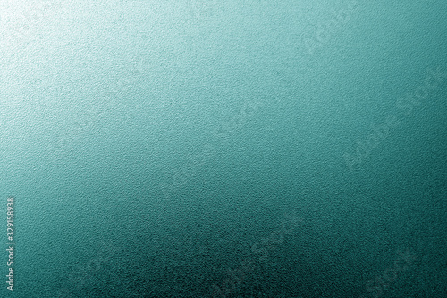 Ground glass texture with light with blur effect in cyan tone.