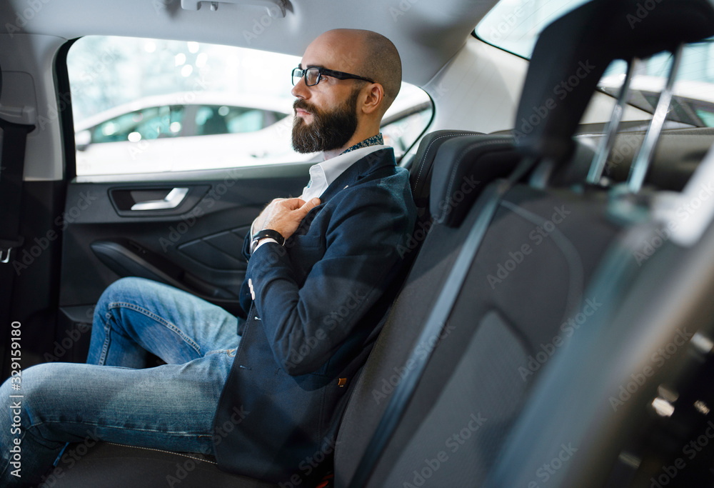 Man checks the comfort of rear seats in automobile Man checks the comfort of rear seats in automobile