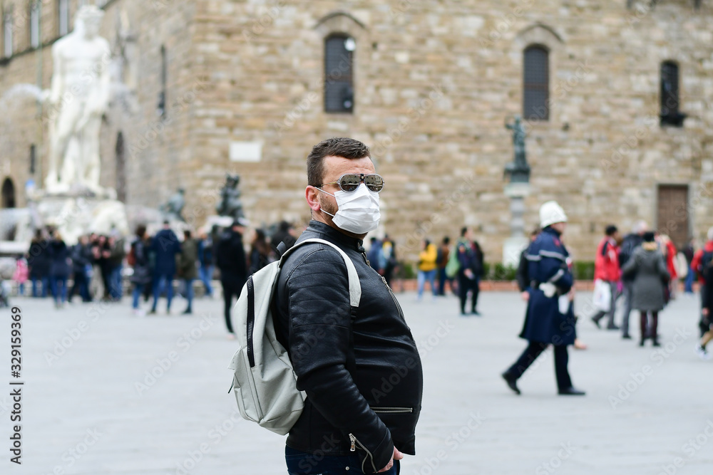 Obraz premium Coronavirus Covid-2019 in Italy. Man in a protective medical mask on a street in a city in Florence Italy. Streets and squares of Italy without tourists.