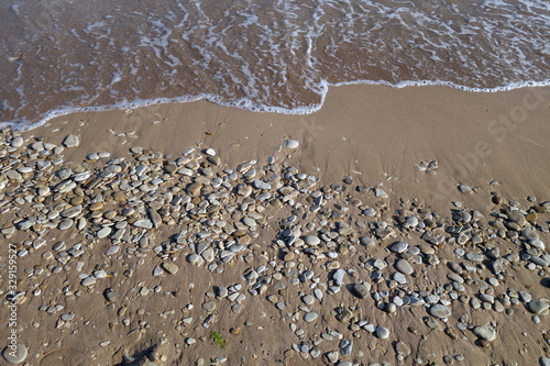 Small stones sand and sea wave.