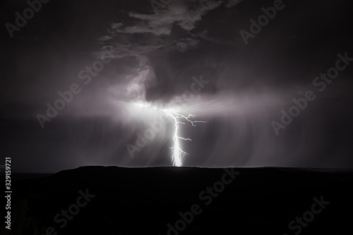 Bolt of lightening striking the ground at night