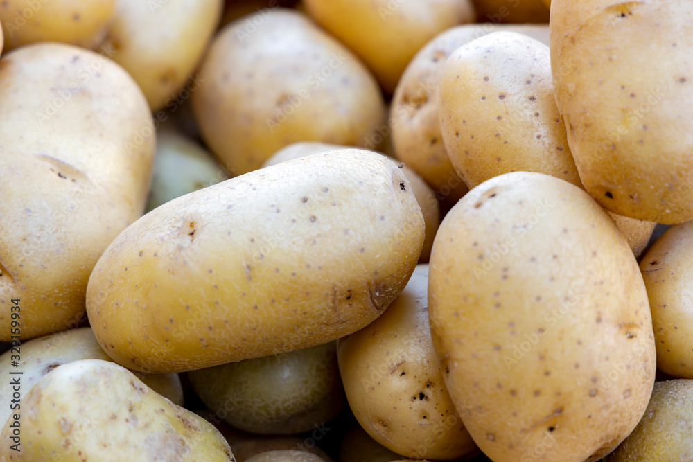 Raw potatoes close-up at a farmers market. Raw potatoes close-up at a farmers market.