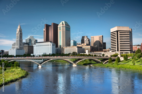 Downtown cityscape looking over the Scioto River and the Discovery Bridge along the Riverfront Park in the city of Columbus Ohio USA © Aevan