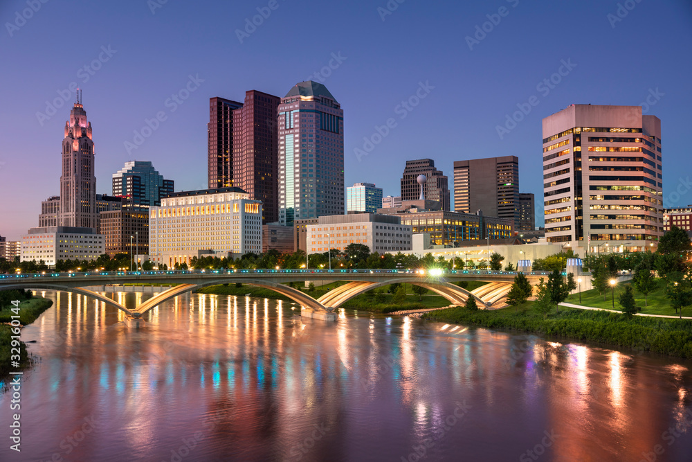 Fototapeta premium Downtown cityscape looking over the Scioto River and the Discovery Bridge along the Riverfront Park in the city of Columbus Ohio USA