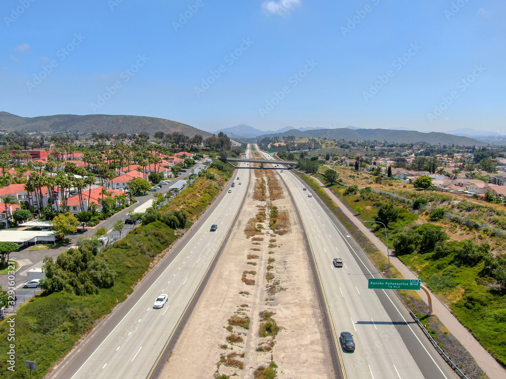 Aerial view of highway surrounded by villa in suburb. Intersection city transport road with vehicle movement. California, USA.
