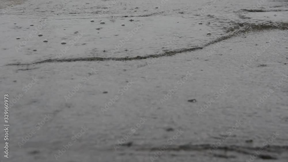 a stream of gray rainwater with traces of falling drops a stream of gray rainwater with traces of falling drops