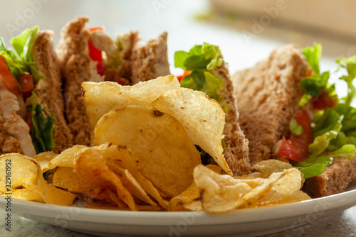 Sandwiches with potato chips or crisps in the foreground
