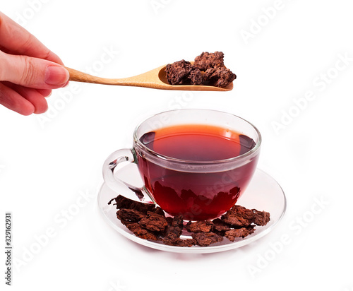 The cup of the chinese puer tea with scoop in hand isolated on a white background. photo