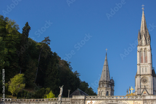 Sanctuary of Our Lady in Lourdes  France. Famous religious centre of pilgrims. Aerial view of catholic cathedral on mountains background. Spiritual travel.