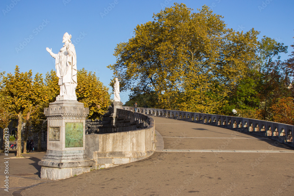 Lourdes, France - 09/29/2019: Statues of saints in park near Sanctuary of Our Lady in Lourdes, France. Famous religious centre of pilgrims. Spiritual travel. Faith and miracle concept.