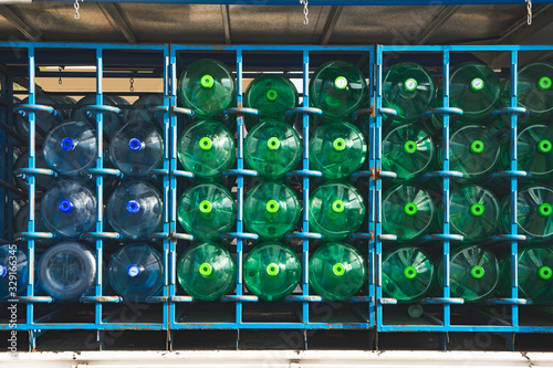 Bidones de agua mineral, botellones de plástico, verde y azul, dentro de un camion.