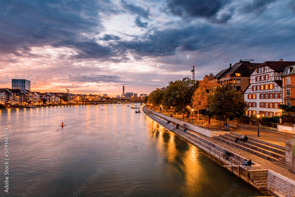 Basel, Switzerland. View over Rhine river at Basel city during amazing sunset. Amazing seasonal autumnal scenery.