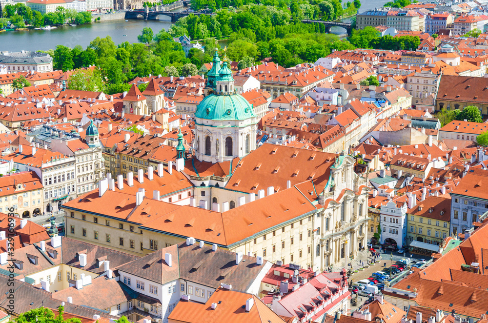 Top aerial view of Prague historical city centre with red tiled roof buildings in Mala Strana Lesser Town, Church of Saint Nicholas, Vltava river background, Bohemia, Czech Republic