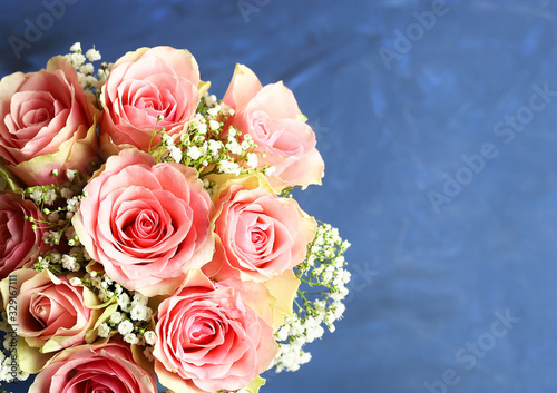 Sfondo per la cartolina. Bouquet di rose rosa su sfondo blu. Vista dall'alto.