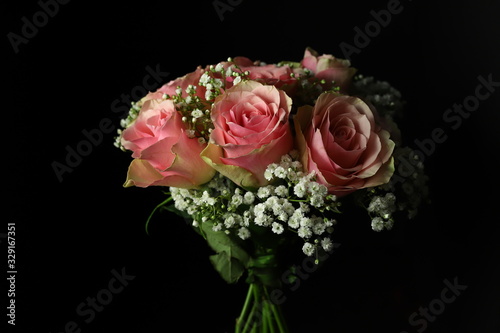 Mazzo di rose rosa isolato su sfondo scuro. Primo piano.