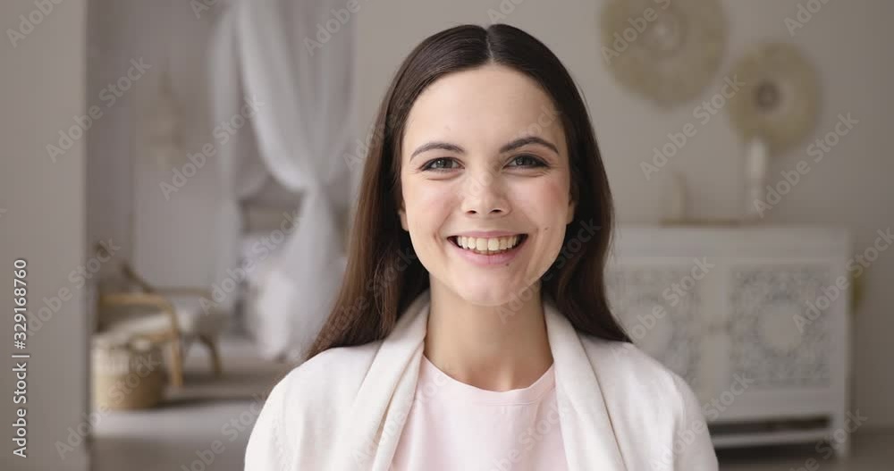 Cheerful millennial woman looking at camera posing at home. Happy young adult girl interior designer posing in cozy light apartment. Smiling confident positive lady laughing indoors, close up portrait Cheerful millennial woman looking at camera posing at home. Happy young adult girl interior designer posing in cozy light apartment. Smiling confident positive lady laughing indoors, close up portrait