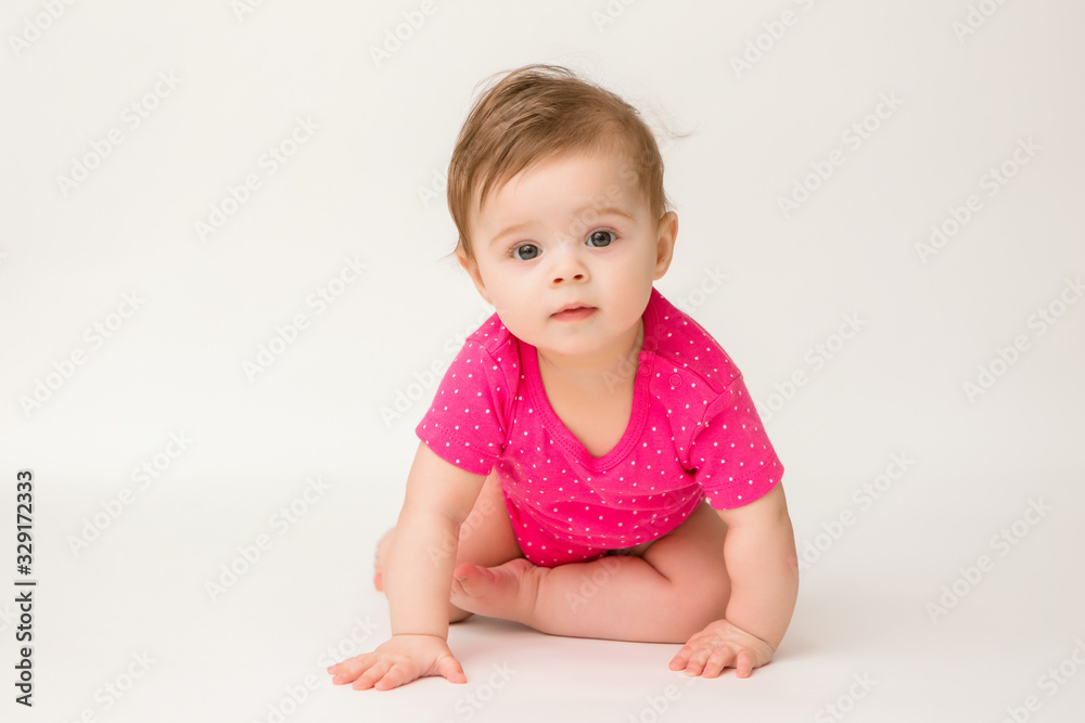healthy baby girl in a pink bodysuit sits on a white background. space for text healthy baby girl in a pink bodysuit sits on a white background. space for text