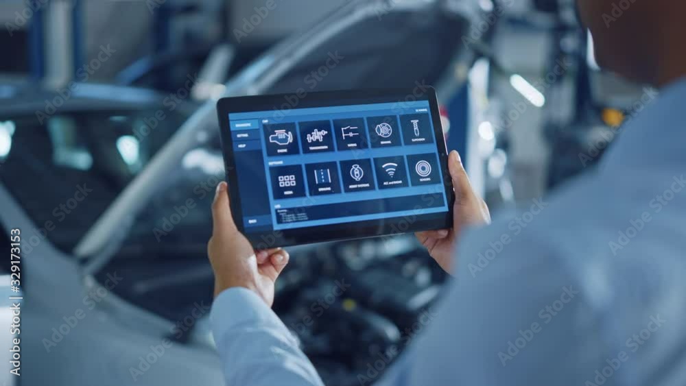 Car Service Manager or Mechanic Uses a Tablet Computer with a Futuristic Interactive Diagnostics Software. Specialist Inspecting the Vehicle in Order to Find Broken Components In the Engine Bay.