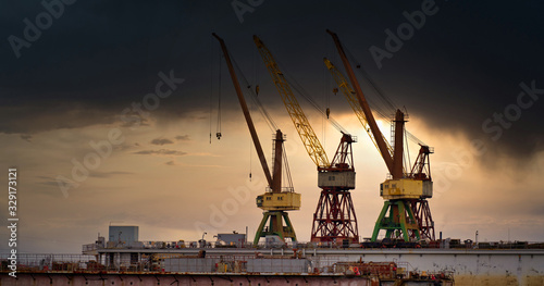 Massive blue, orange and yellow cranes in harbour photo