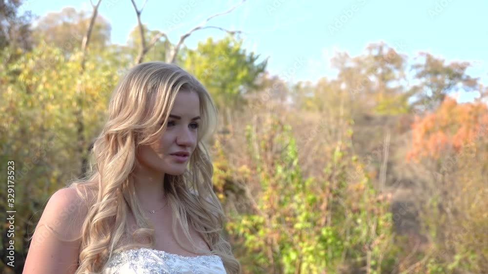 Portrait of tender bride blonde basking in sun at the autumn park. Video shooting movement camera with steadicam. Portrait of tender bride blonde basking in sun at the autumn park. Video shooting movement camera with steadicam.