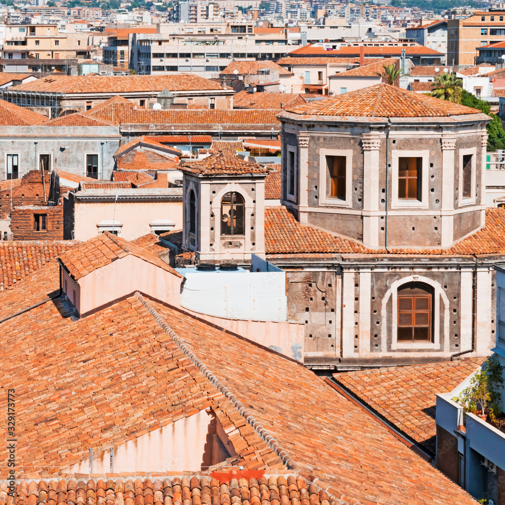 Detail of skyline view of Catania old town featuring ochre, brown and yellow roofs and churches. Sicily, Italy. Mediterranean urban background. 