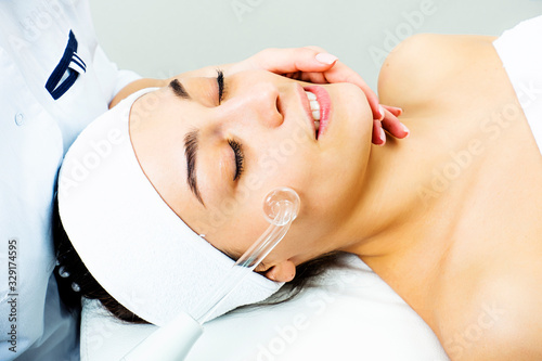 Darsonvalization of the face. Procedure darsonvalization of a female face close-up. photo