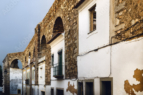 Houses in Evora  Alentejo  Portugal  along the ancient Agua da Prata aqueduct. Buildings were built during centuries directly between the arches of the aqueduct