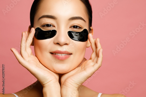 Asian beauty model concept. Attractive young woman applying black eye patches