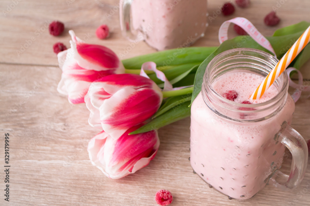 Refreshing raspberry smoothie made with milk and fresh raspberries. Tulip flowers and tape mesure, spring concep Refreshing raspberry smoothie made with milk and fresh raspberries. Tulip flowers and tape mesure, spring concep