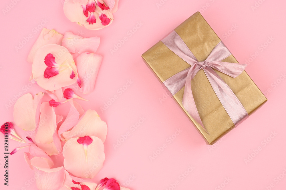 Flat lay composition with beautiful flowers and a gift box on a pink background. Space for text Flat lay composition with beautiful flowers and a gift box on a pink background. Space for text