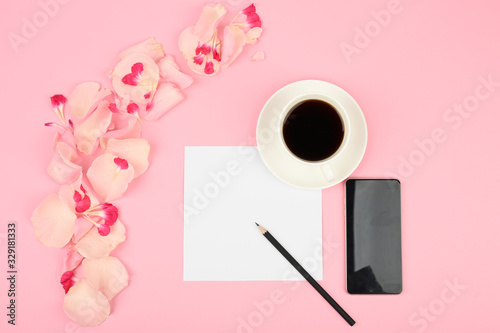 The concept of day planning. A cup of coffee, white card, pink flowers. Flat lay