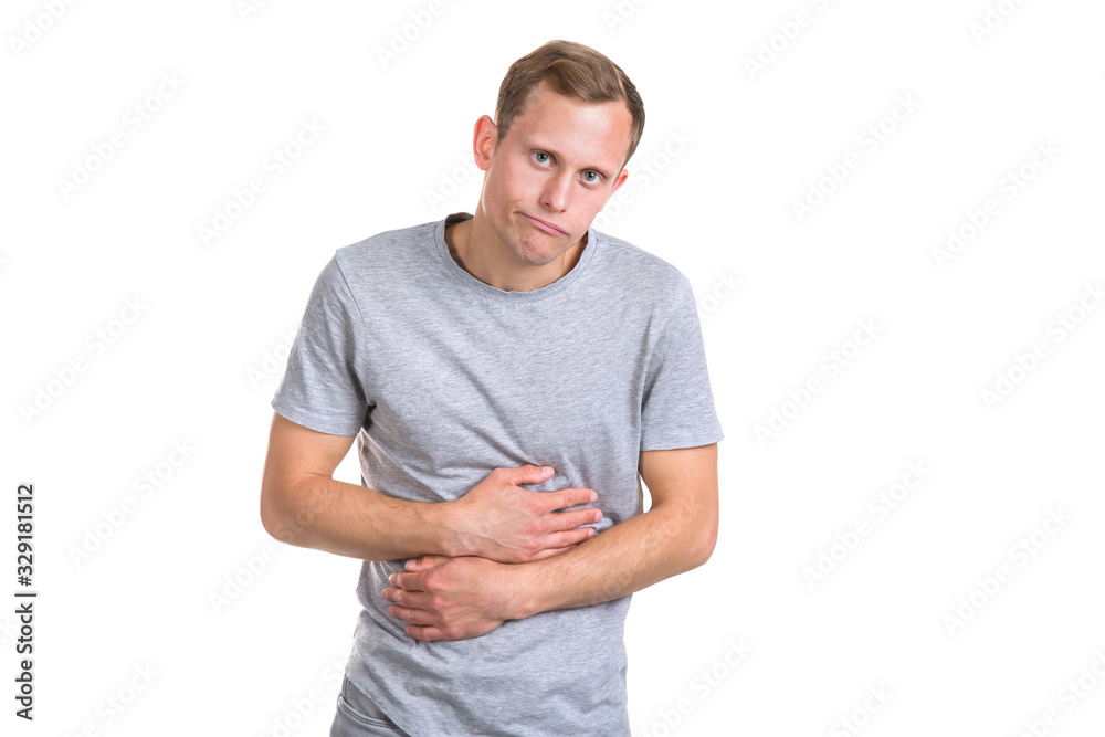 Sick young man holding his belly with his hands, isolated on a white background. Pain in the stomach, constipation in the intestines. Sick young man holding his belly with his hands, isolated on a white background. Pain in the stomach, constipation in the intestines.
