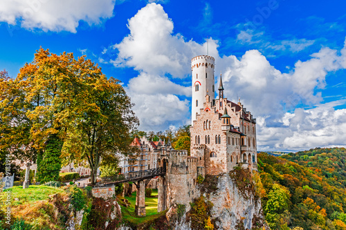 Germany, Lichtenstein Castle in Baden-Wurttemberg land in Swabian Alps. Seasonal view of Lichtenstein Castle on a cliff circled by trees with yellow foliage. European famous landmark. photo