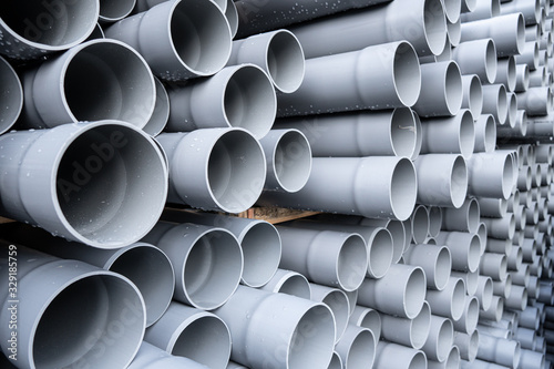 Gray PVC tubes plastic pipes stacked in rows photo