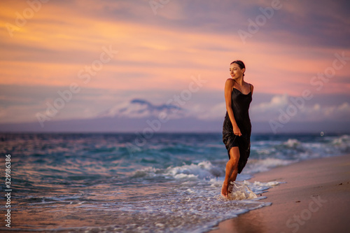Beautiful woman by the ocean at sunset © Maygutyak