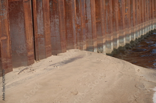 Steel piles that strengthen the shore at the border of water and sand