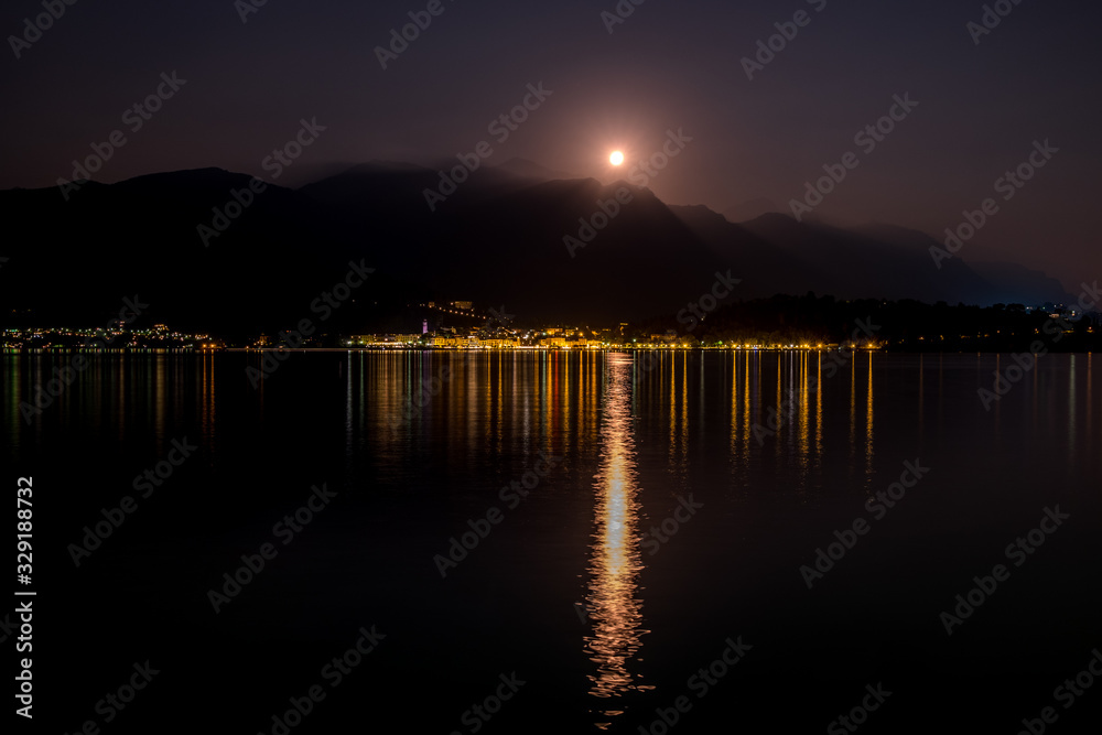 Lake Como reflects full moon and lights of Bellagio, Italy Lake Como reflects full moon and lights of Bellagio, Italy