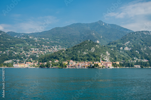 Varenna, Italy sits beside Lake Como beneath forested mountains © Annee
