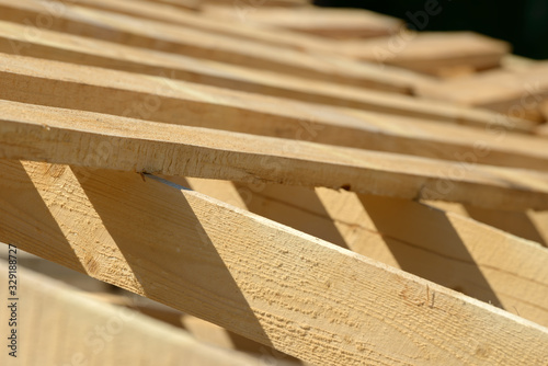 Wood board assembled on construction site. New frame structure of building. Scaffolding framework made from natural materials. Wooden floor or ceiling. Elements and components of the construction.