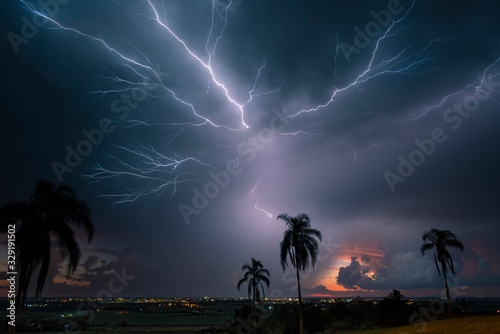 Lightning creeps across the sky during a storm shortly after the sun has set.